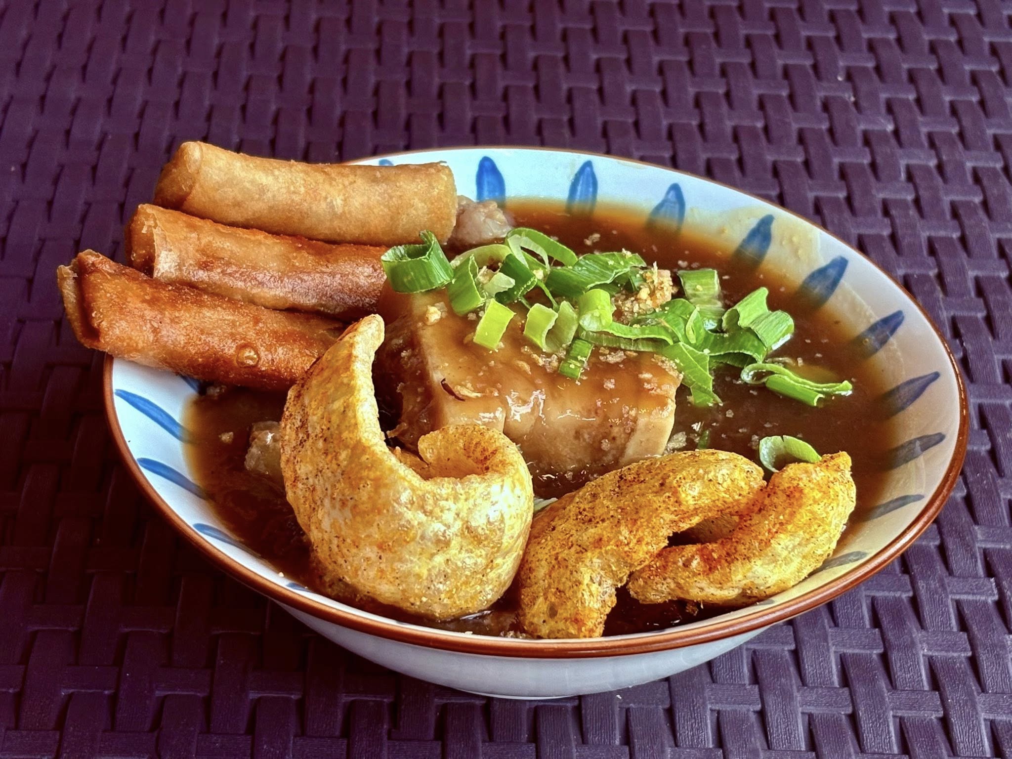 Beef pares with chicharon and lumpia in savory soup